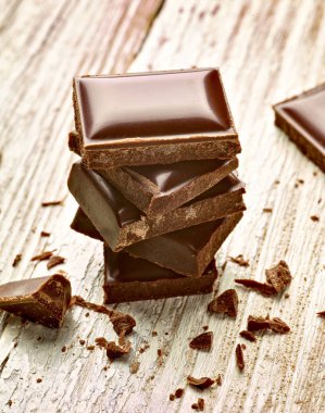 Tahta arka planda çikolata parçalarını kapat