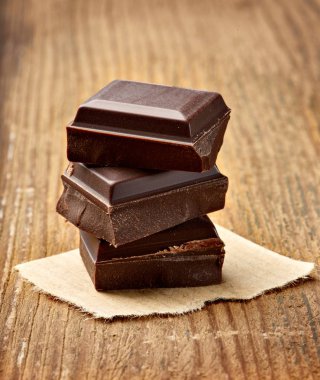 Tahta arka planda çikolata parçalarını kapat