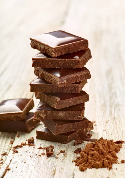 Tahta arka planda çikolata parçalarını kapat