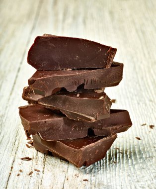 Tahta arka planda çikolata parçalarını kapat