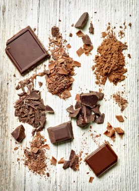 Tahta arka planda çikolata parçalarını kapat