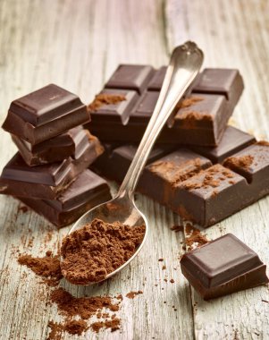 Tahta arka planda çikolata parçalarını kapat