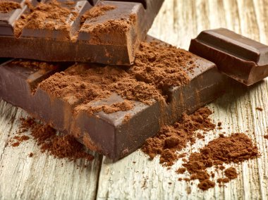 Tahta arka planda çikolata parçalarını kapat