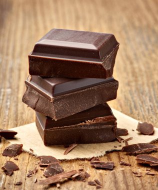 Tahta arka planda çikolata parçalarını kapat