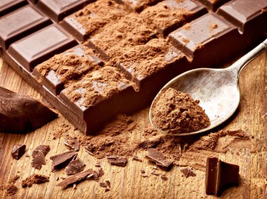 Tahta arka planda çikolata parçalarını kapat