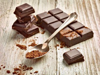 Tahta arka planda çikolata parçalarını kapat