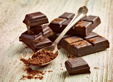 Tahta arka planda çikolata parçalarını kapat