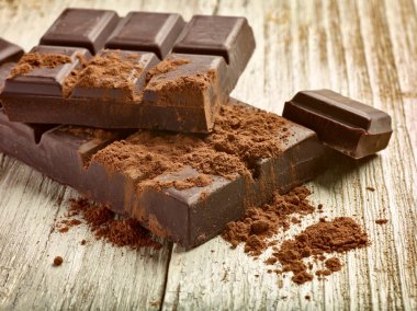 Tahta arka planda çikolata parçalarını kapat