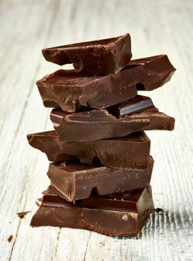 Tahta arka planda çikolata parçalarını kapat