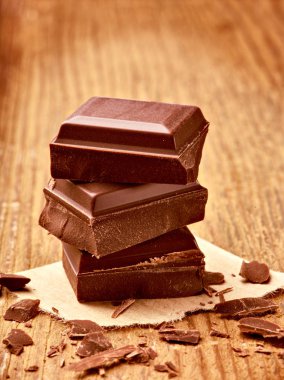 Tahta arka planda çikolata parçalarını kapat