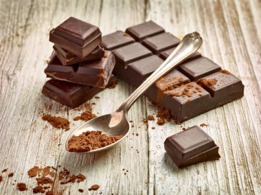 Tahta arka planda çikolata parçalarını kapat