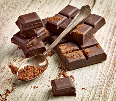 Tahta arka planda çikolata parçalarını kapat