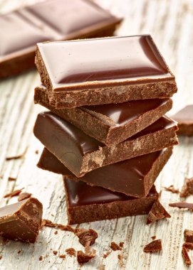 Tahta arka planda çikolata parçalarını kapat