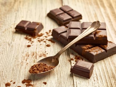 Tahta arka planda çikolata parçalarını kapat