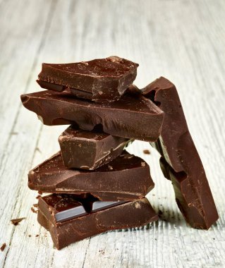 Tahta arka planda çikolata parçalarını kapat