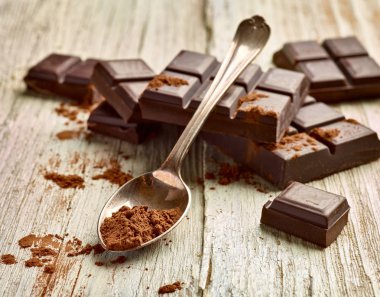 Tahta arka planda çikolata parçalarını kapat