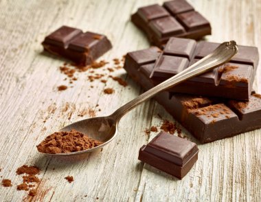 Tahta arka planda çikolata parçalarını kapat