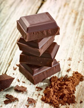 Tahta arka planda çikolata parçalarını kapat