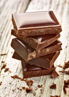 Tahta arka planda çikolata parçalarını kapat