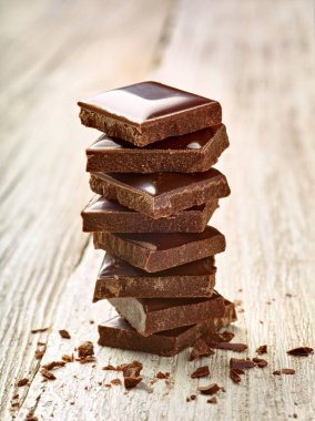 Tahta arka planda çikolata parçalarını kapat