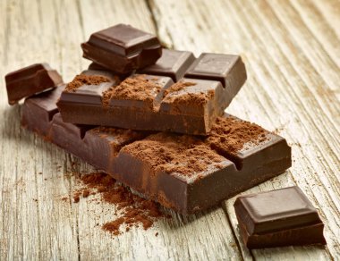 Tahta arka planda çikolata parçalarını kapat