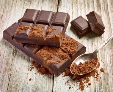 Tahta arka planda çikolata parçalarını kapat