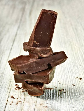 Tahta arka planda çikolata parçalarını kapat