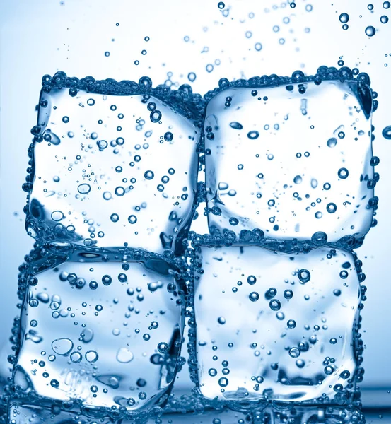 Respingo de cubo de gelo na água fria — Fotografia de Stock