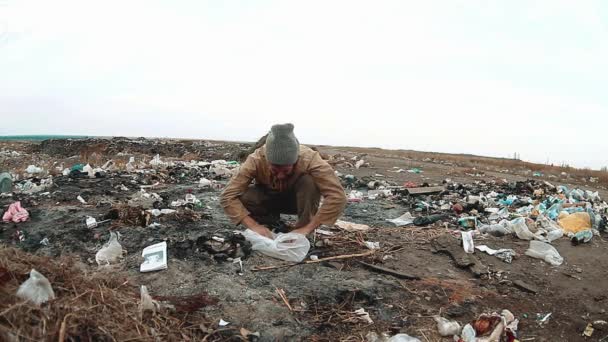 Man homeless dump in a landfill homeless looking for food among the garbage. social concept lifestyle problem poverty hunger man. problem of poverty and social inequality concept — Stock Video