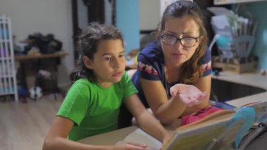 Anne ve kızı ev ödevi okul yapmak. ağır çekim video. hazırlık, okul için. küçük kız ve kadın çalışması bir yaşam tarzı kitapla. okul çocuklar Aile kavramı