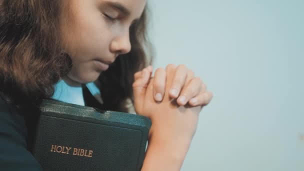 La bibbia santa della bambina prega con la bibbia in mano. la sacra Bibbia del cattolicesimo. bambini e religione educazione simbolo di fede. Ragazzina con stile di vita orante. Pace, speranza, sogni — Video Stock