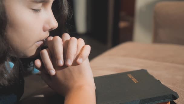 Kislány, imádkozott éjjel. Kis lány kezét imádkozott. kis lány Szent Biblia imádkozik, a Biblia a kezében. a katolicizmus Szent Bibliát. a gyermekek és a vallás nevelés életmód hit — Stock videók