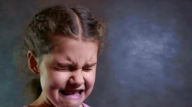üzgün ve depresyonda yaşam tarzı beyaz bir arka plan üzerine ağlamaya değer küçük kız. ağır çekim video. küçük üzgün kız akışı gözyaşları. Genç kız üzgün depresyon kavramı