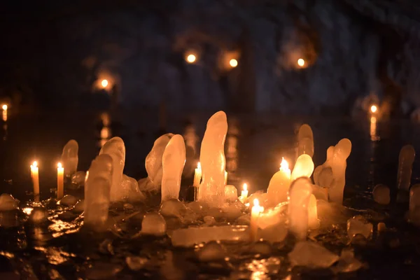 冬の洞窟の中でキャンドルに照らされた氷の石筍 — ストック写真