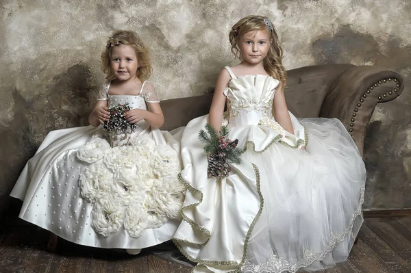 two young princesses in white are sitting