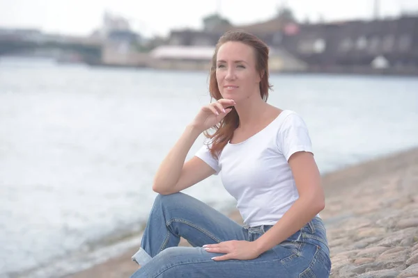 Mulher Jeans Shirt Branca Senta Beira Água — Fotografia de Stock