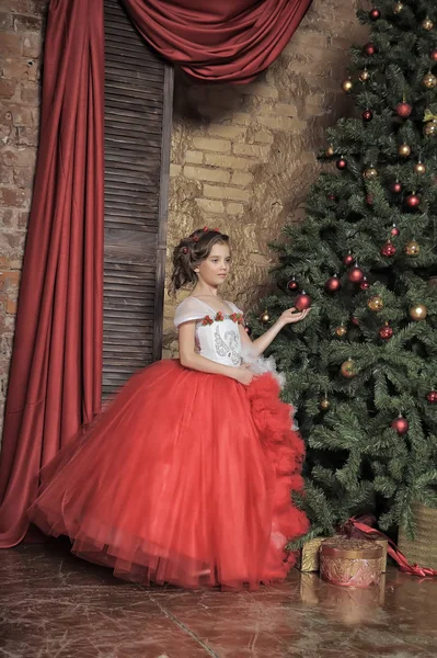 クリスマスに赤と白のドレスの若い王女 — ストック写真