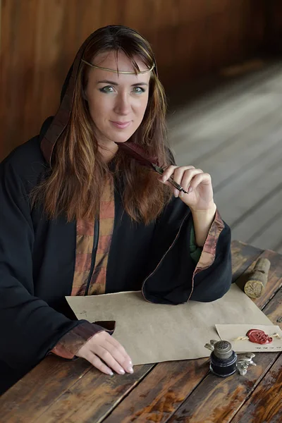 Eine Frau Mittelalterlichen Mantel Sitzt Mit Einem Stift Und Schreibt — Stockfoto
