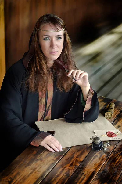 Eine Frau Mittelalterlichen Mantel Sitzt Mit Einem Stift Und Schreibt — Stockfoto