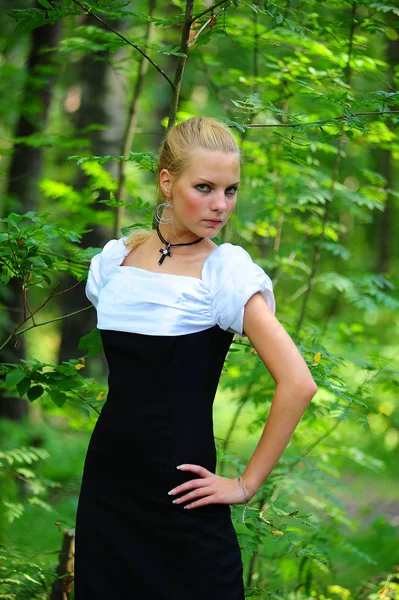 年轻的金发女郎在一个公园在黑色与白色礼服 — 图库照片