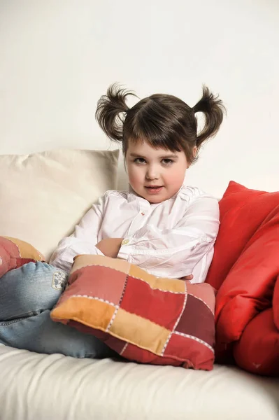 Kleines Brünettes Mädchen Auf Der Couch Mit Kissen — Stockfoto