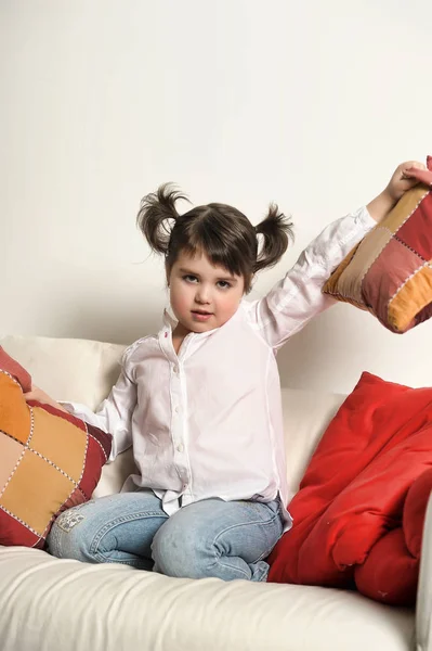 Kleines Brünettes Mädchen Auf Der Couch Mit Kissen — Stockfoto