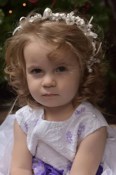 年轻女孩小公主在一个白色的节日礼服与蓝色的皮带 — 图库照片