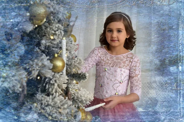 可爱的女孩在一个粉红色的礼服在工作室在新年的装饰和圣诞树 — 图库照片