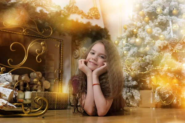 クリスマス ツリーの近くの床に横たわっているブルネットの少女 — ストック写真