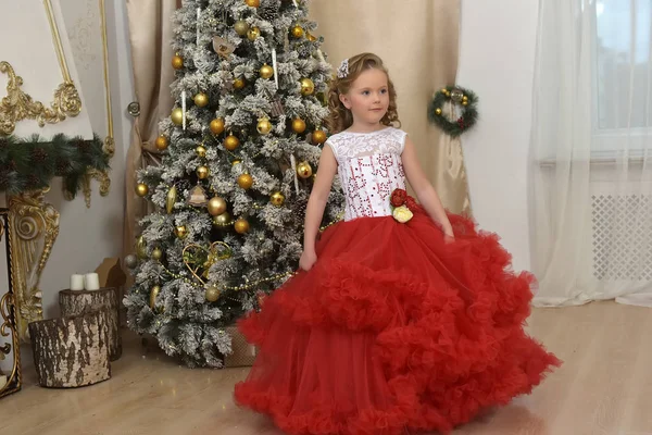 beautiful girl dancing in red with white dress in christmas by the christmas tree