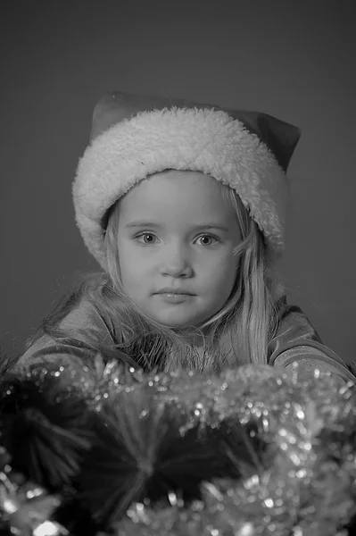 Kleines Blondes Mädchen Mit Weihnachtsmütze Mit Girlanden — Stockfoto