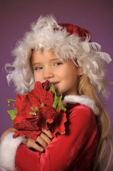 クリスマスの花束とクリスマスの帽子の美しい金髪の少女の肖像画 — ストック写真