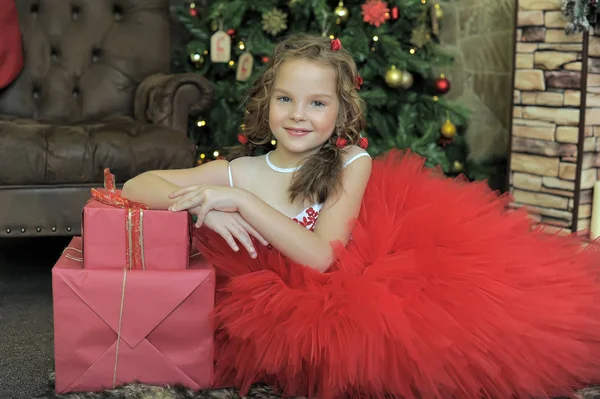 クリスマス ツリーでお土産に赤いドレスを着た美しいエレガントな女の子 — ストック写真