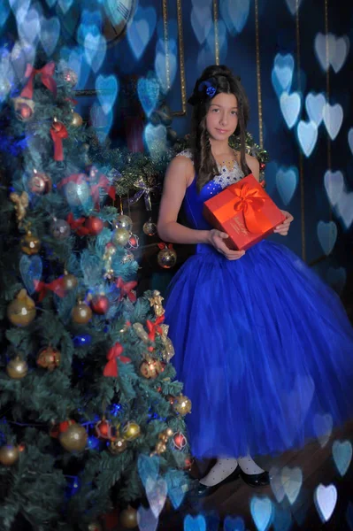幸福的女孩在蓝色礼服与圣诞节礼物 — 图库照片